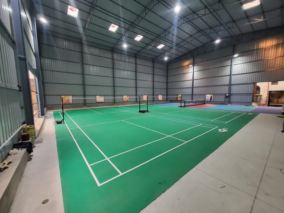 Two badminton courts beside a pickleball court, built by Kelysports inside a new steel-framed sports shed.