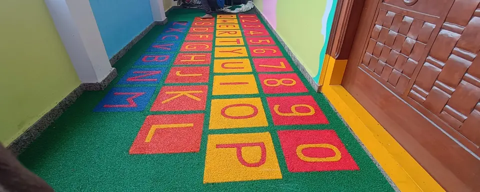 Alphabet and number grid set into green EPDM flooring along a corridor.