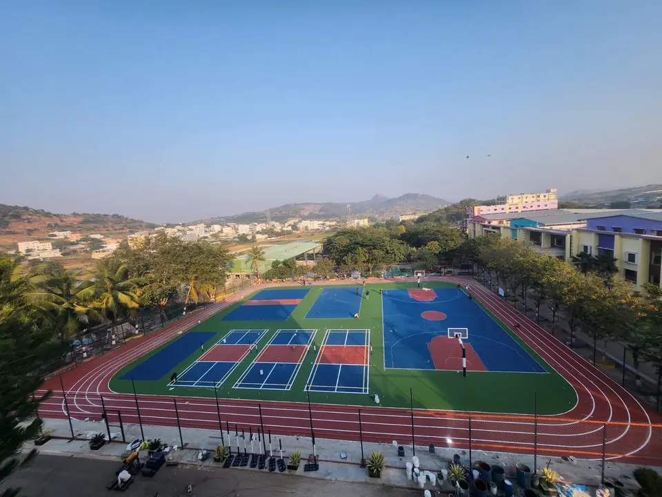 Large sports ground with three pickleball courts, a basketball court and further court areas, ringed by a running track.