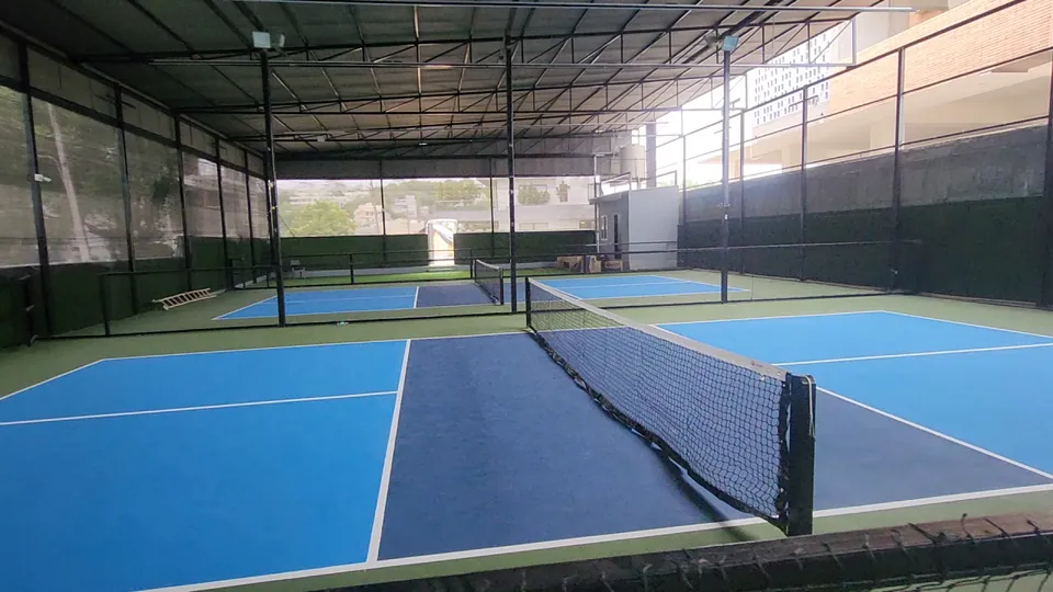 Pickleball net stretched across a court at Rayadurgam, with the dark blue non-volley zone and white lines beside it.