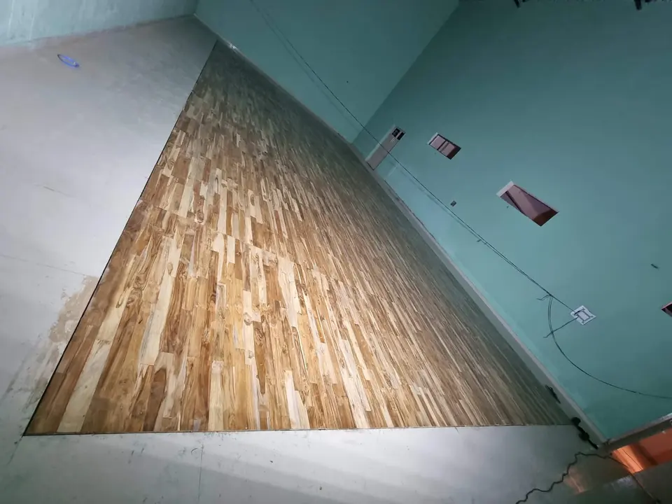 High-angle view of newly laid teak floor boards showing the natural variation in teak grain and colour.