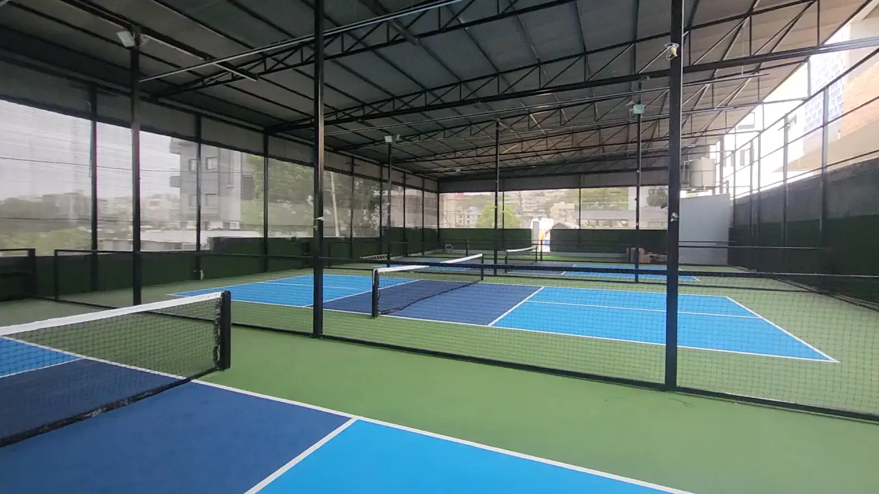 Walk-through of the covered pickleball courts Kelysports built at Rayadurgam, Hyderabad: blue courts with a green surround, divided by netting under a steel roof
